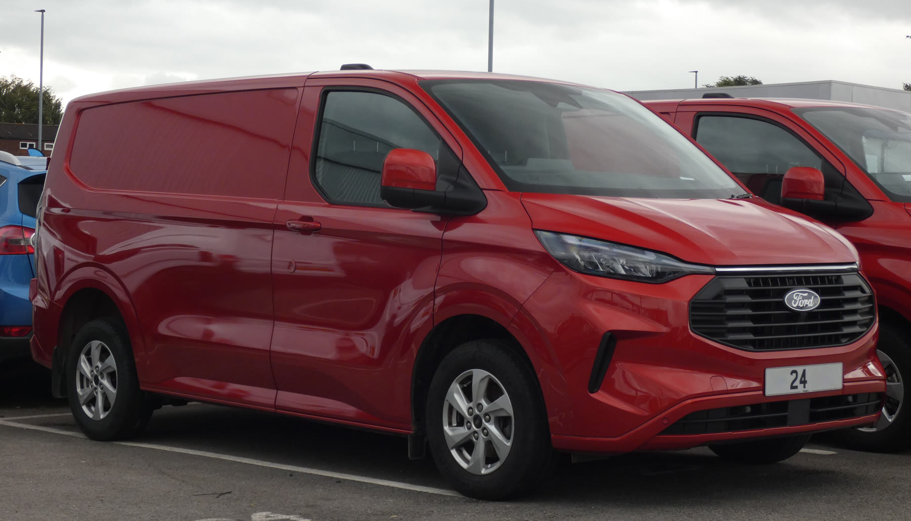 Κόκκινο Ford Transit Custom Limited 2.0 TDCi του 2024, μπροστινή όψη. Λήψη της 25ης Αυγούστου 2024. Δεν είναι όχημα της ελληνικής ανάκλησης και δεν φαίνεται η σωλήνωση καυσίμου.
