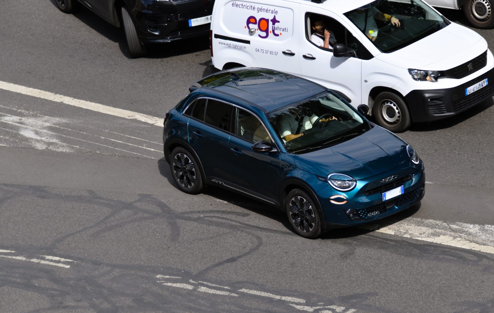 Πορτοκαλί Fiat 600 Hybrid 1.2 του 2025, σε μπροστινή τριτέταρτη όψη, σταθμευμένο σε άσφαλτο με δέντρα στο βάθος