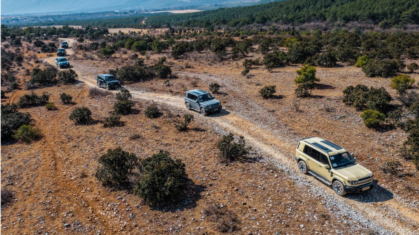 Ασημί iCAUR V27 σε βραχώδες έδαφος, μπροστινή τριών τετάρτων όψη, με μαύρη οροφή και εξωτερική ρεζέρβα στην πίσω πόρτα